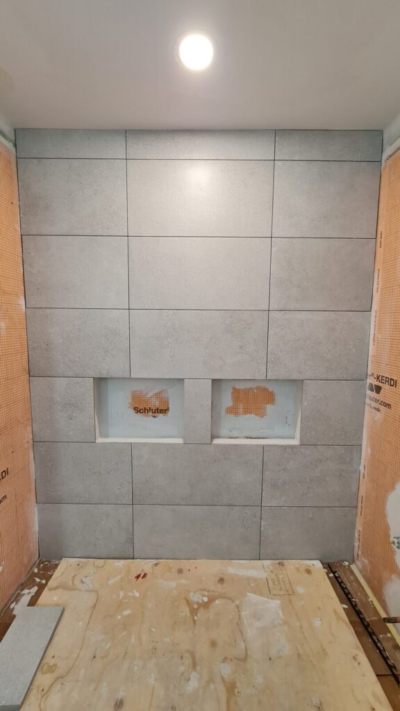 Wall tiling in progress around the new bathtub