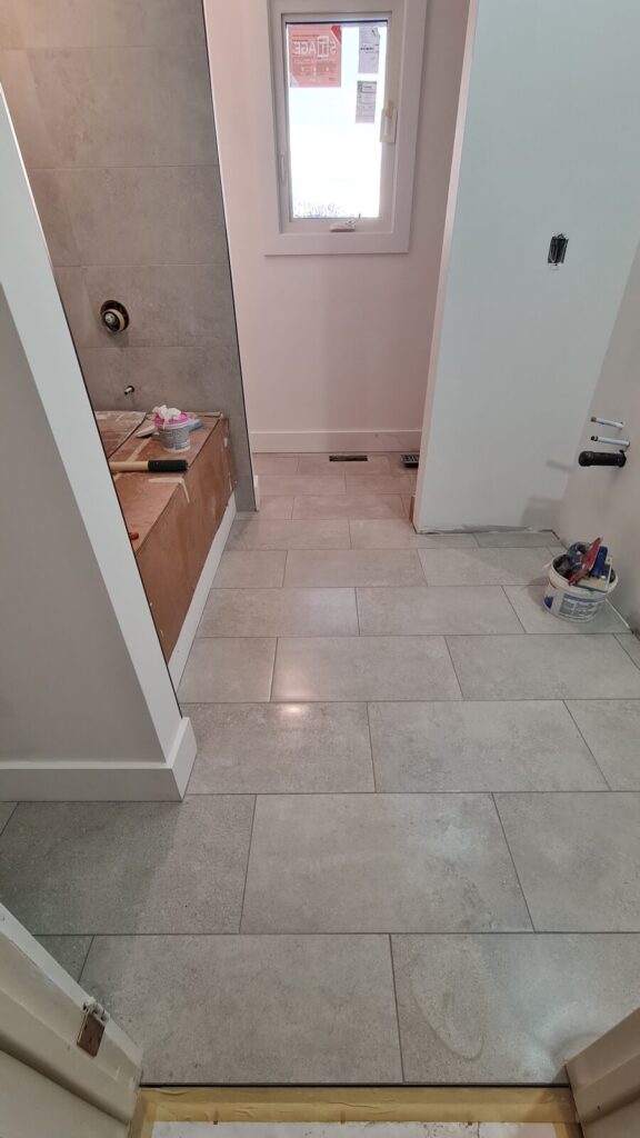 Large-format porcelain floor tile installation in progress