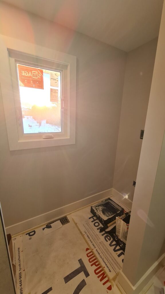 Finished bathtub area with tiled walls and natural light