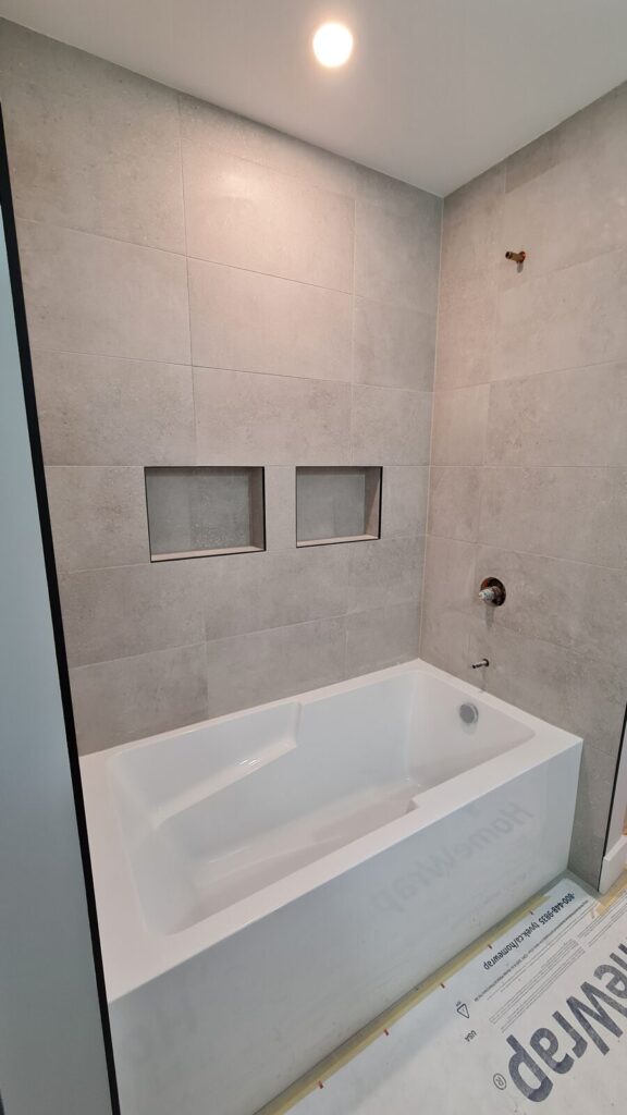 Built-in niches in the bathtub surround finished in porcelain tile